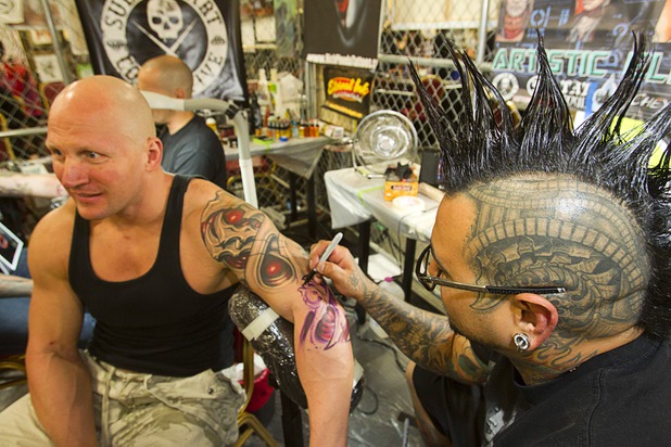 Tattoo artist Roman Abrego works on Donovan Middleton during the inaugural Art N Ink Festival at the South Point Sunday, June 30, 2013.