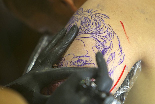 A tattoo artist works on a tattoo during the inaugural Art N Ink Festival at the South Point Sunday, June 30, 2013.