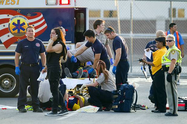 Emergency medical technicians work on an injured fan after a fight between fans of Chivas Guadalajara and Club America before El Super Clasico soccer game at Sam Boyd Stadium, Wednesday, July 3, 2013. Witnesses said 150-200 people were involved in the altercation.
