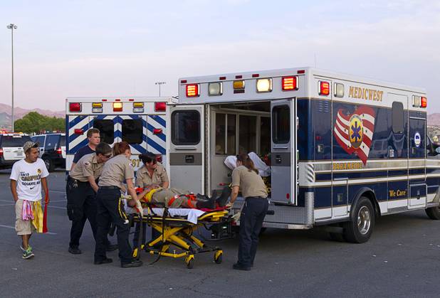 An injured fan is loaded into an ambulance after a fight between fans of Chivas Guadalajara and Club America before El Super Clasico soccer game at Sam Boyd Stadium, Wednesday, July 3, 2013. Witnesses said 150 to 200 people were involved in the altercation.
