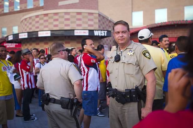 Metro police office keep a eye on fans after a fight between fans of Chivas Guadalajara and Club America before El Super Clasico soccer game at Sam Boyd Stadium, Wednesday, July 3, 2013. Witnesses said 150-200 people were involved in the altercation.