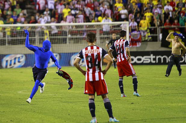 Players from Chivas Guadalajara watch as fans run onto the field during El Super Clasico soccer game at Sam Boyd Stadium Wednesday July 3, 2013.