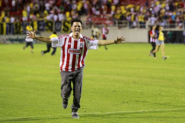 A fan runs onto the field during El Super Clasico soccer game at Sam Boyd Stadium Wednesday July 3, 2013.