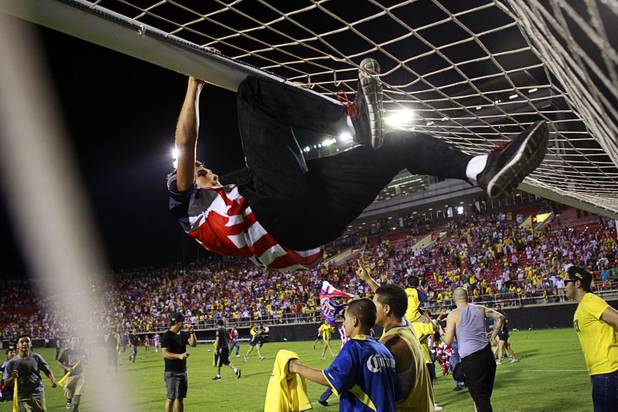 A fan climbs onto the goal El Super Clasico soccer game at Sam Boyd Stadium Wednesday July 3, 2013.