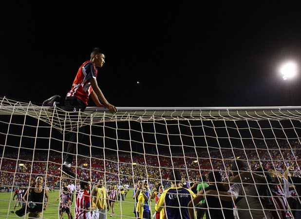 A fan sits on top of the goal after El Super Clasico soccer game at Sam Boyd Stadium Wednesday July 3, 2013.