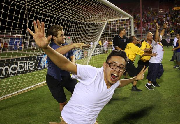 Security pushes fans away from the goal after El Super Clasico soccer game at Sam Boyd Stadium Wednesday July 3, 2013.