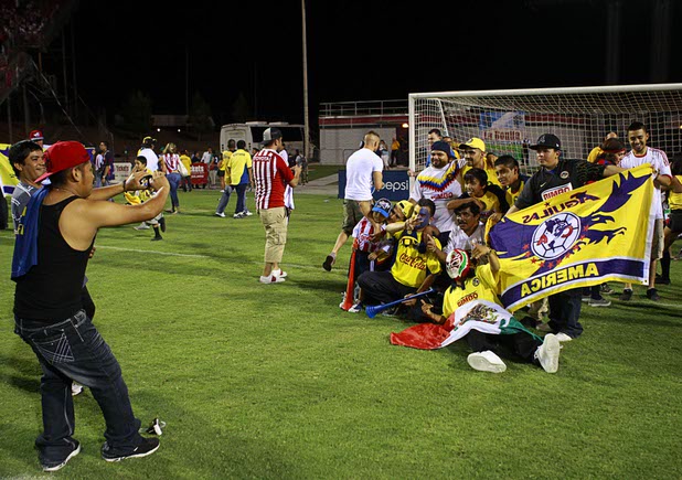 Fans pose on the field after El Super Clasico soccer game at Sam Boyd Stadium Wednesday July 3, 2013.