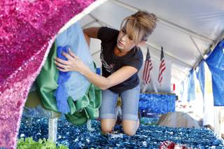 Volunteer Elizabeth Engle puts the finishing touches on floats for the Summerlin Council Patriotic Parade on Wednesday, July 3, 2013.