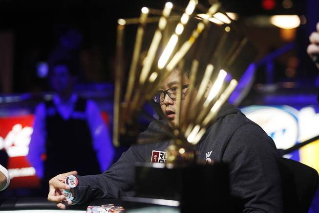 Don Nguyen is seen through the David "Chip" Reese Trophy during the final table of the Poker Players Championship Thursday, July 4, 2013 at the Rio.