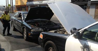 Metro Sgt. Andre Bates helps a woman jump-start her car at the corner of Sixth and Fremont streets July 5, 2013.
