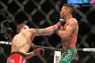 Frankie Edgar hits Charles Oliveira with a right during their fight at UFC 162 Saturday, July 6, 2013 at the MGM Grand Garden Arena. Edgar won by unanimous decision.
