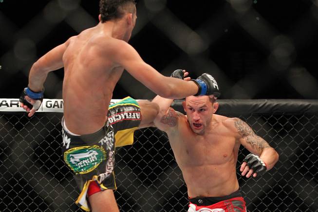 Frankie Edgar blocks a kick from Charles Oliveira during their fight at UFC 162 Saturday, July 6, 2013 at the MGM Grand Garden Arena. Edgar won by unanimous decision.