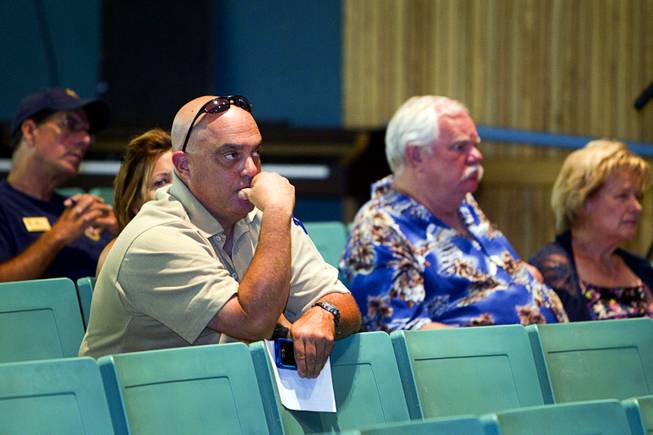 Trout Canyon homeowner Tony Russo, left, listens during a wildfire briefing for the media at Centennial High School Sunday, July 7, 2013. Merle and Nancy Barber, right, homeowners in the Rainbow subdivision on Mount Charleston, also attended.
