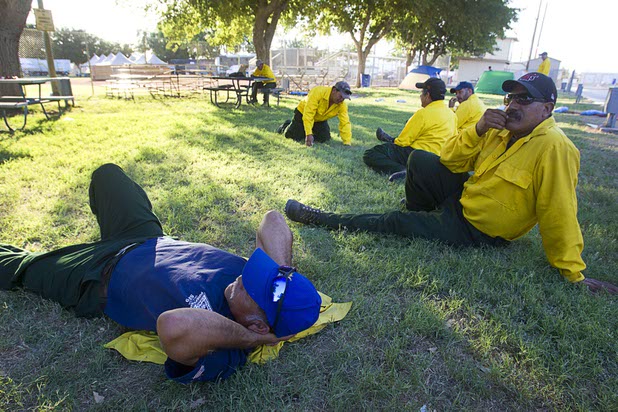 Firefighter Emiliano Perez, right, waits for an assignment with other members of his crew at Petrack Memorial Field in Pahrump Sunday, July 7, 2013. The Bureau of Land Management crew is from Vale, Oregon but was recently fighting a fire near Battle Mountain in Northern Nevada, he said. 