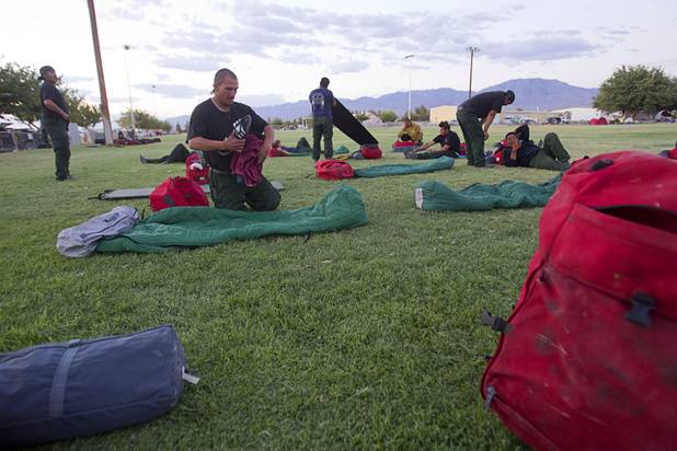 Phillip Martinez, center, based in Owyee, Nev. prepares to camp in Pahrump after fighting the Carpenter 1 wildfire Sunday, July 7, 2013.