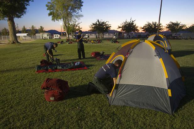 Firefighter Todd Heon, center, of the Angeles National Forest sets up a tent in Pahrump after fighting the Carpenter 1 wildfire Sunday, July 7, 2013.