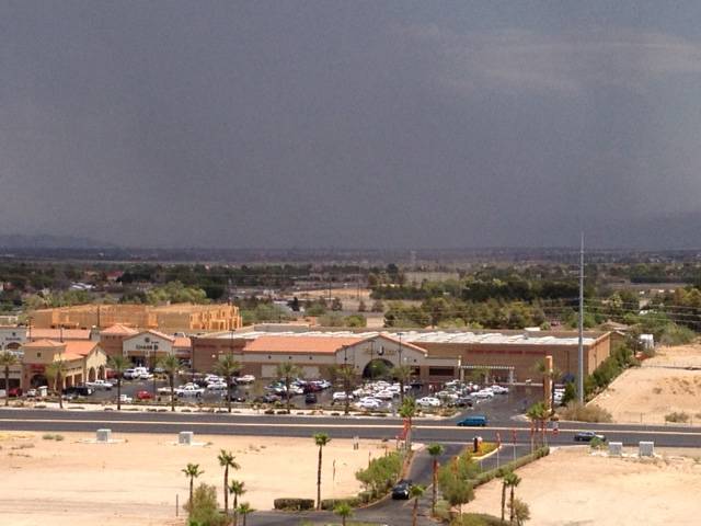 As the western Las Vegas Valley experienced sunshine early Sunday afternoon, thunderstorms rolled through Henderson and eastern Las Vegas. This image, facing northeast, shows a strip mall at Las Vegas Boulevard and Windmill Lane in the foreground. 