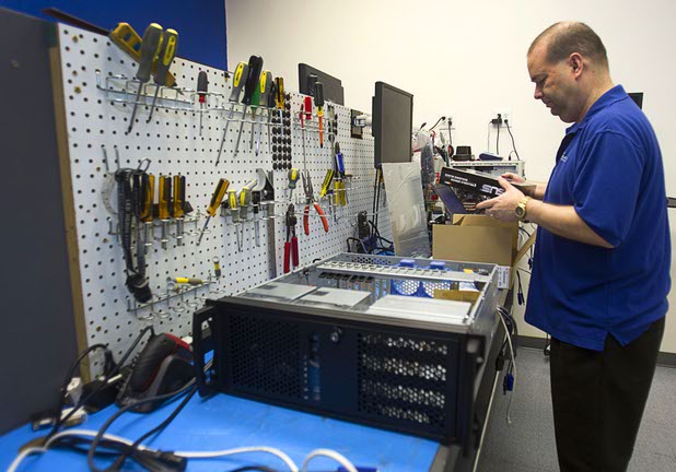 Technician Richard Tracy assembles a server on a work bench at Stimulus Technologies in Henderson Monday, July 8, 2013.