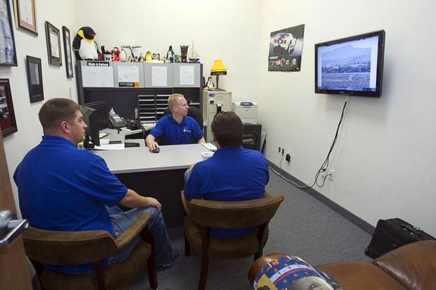 Nathan Whittacre, center, president of Stimulus Technologies, listens to Michael Maddy, left, and Kyle Hood as they discuss a new installation for a client in Henderson Monday, July 8, 2013.