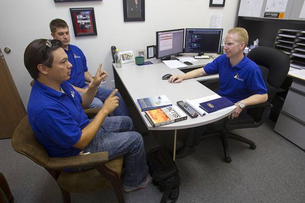 Nathan Whittacre, right, president of Stimulus Technologies, listens to Kyle Hood, left, as they discuss a new installation for a client in Henderson Monday, July 8, 2013.  Michael Maddy listens in the background.