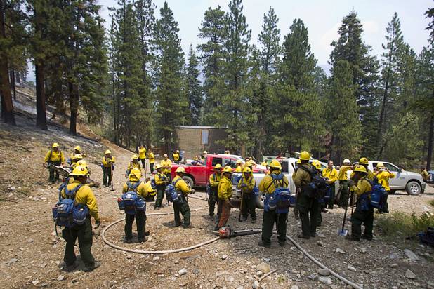 A fire crew prepares to put out hot spots after a burnout in the Rainbow subdivision on Mount Charleston Tuesday, July 9, 2013.