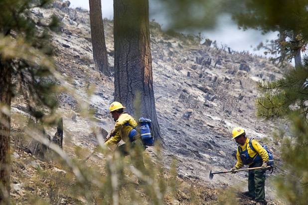A fire crew puts out hot spots after a burnout in the Rainbow subdivision on Mount Charleston Tuesday, July 9, 2013.