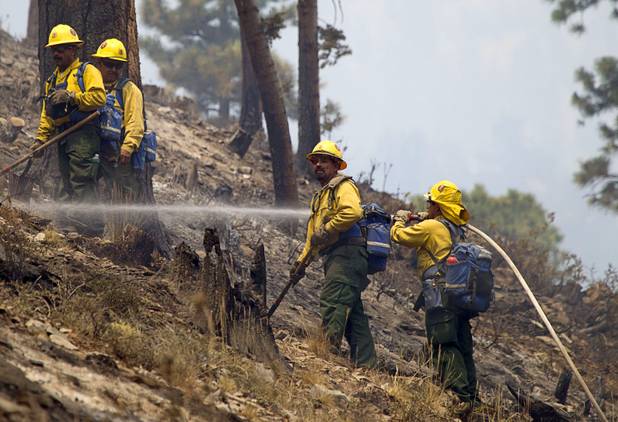 A fire crew puts out hot spots after a burnout in the Rainbow subdivision on Mount Charleston Tuesday, July 9, 2013.