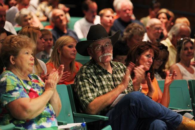 Royce "Woody" Wood and other evacuated residents applaud while being briefed on the progress of fighting the Mt. Charleston fire Wednesday, July 10, 2013 at Centennial High School.