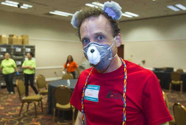 Justin Stills, an audio/visual technician at the MGM Grand, wears a mouse mask as he volunteers in the cat adoption room during the annual Charlies Angels Pet Adoption Fair at the MGM Grand Garden Arena Thursday, July 11, 2013. Scott Sibella, president/COO of MGM Grand, and his wife Kim picked up the adoption fees for any MGM employee that wanted to adopt a dog or cat.