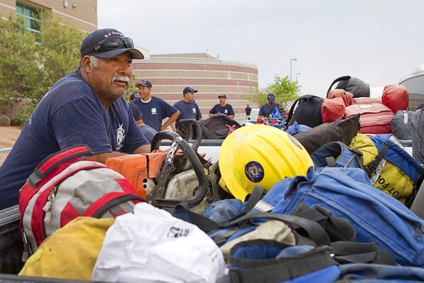 Firefighter Andres Ramos, left, based in Sequoia National Forest, waits to leave Centennial High School and fight the Mount Charleston wildfire Thursday, July 11, 2013.