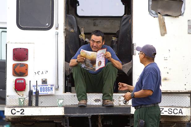 William "Alaska Hensley, based in San Carlos, Ariz., reads a memorial program from a service for 19 fallen firefighters as firefighters prepare to leave Centennial High School and fight the Mount Charleston wildfire Thursday, July 11, 2013. The Hot Shot firefighters were killed June 30 fighting the Yarnell Hill Fire in Arizona.