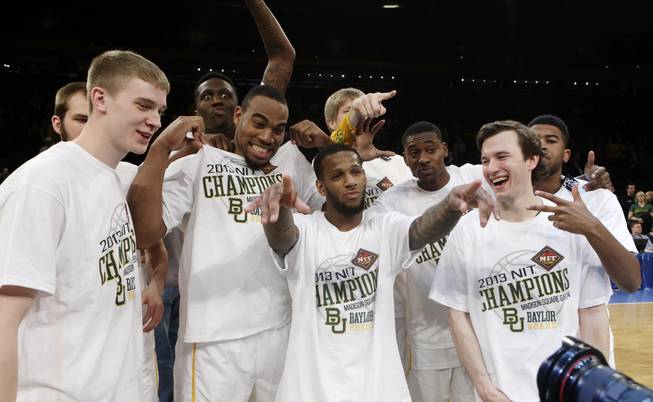 Baylor's Pierre Jackson, center, poses for photographs with teammates after the NIT championship basketball game against Iowa on Thursday, April 4, 2013, in New York. Baylor won 74-54.