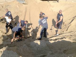 Michigan City police and firefighters dig with shovels to rescue 6 year old Nathan Woessner, of Sterling, Ill., who was trapped for over three hours under about 11 feet of sand at Mount Baldy dune near Michigan City, Ind., on Friday July 12, 2013.  The boy, whose survival was described as a 