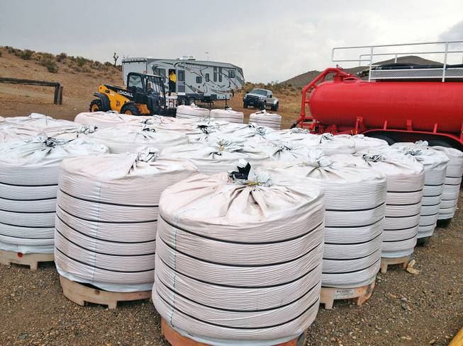 Large bags of fertilizer and red dye are stored near the tanker truck that will mix the powdered substance with water to form a liquid retardant at a mobile production facility near Mount Charleston. The retardant will be used to assist firefighters attacking the wildfire burning farther up the mountain.
