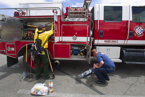 Firefighter/paramedics Charlie Bowman, left, and Mark Secrist display equipment on their Type 3 brush truck at Centennial High School Sunday, July 14, 2013.