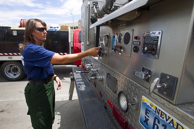 Firefighter/paramedic Jennifer Cleppe talks about pump controls on a Type 3 brush truck at Centennial High School Sunday, July 14, 2013. The truck can carry 700 gallons of water and can also make foam, she said.