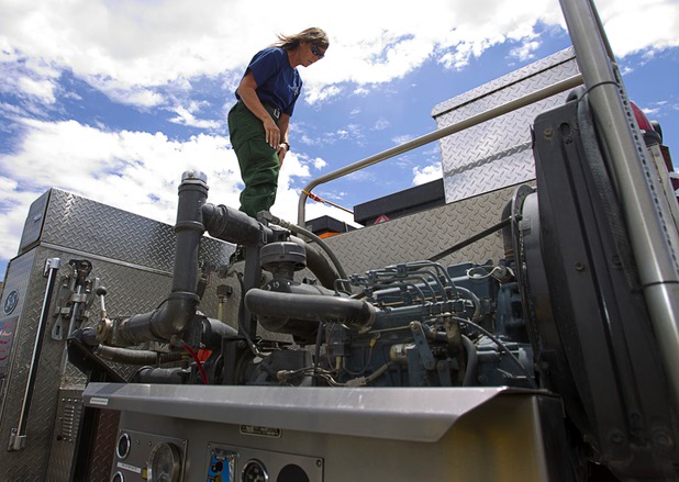 Firefighter/paramedic Jennifer Cleppe stands on a Type 3 brush truck at Centennial High School Sunday, July 14, 2013. The truck can carry 700 gallons of water and can also make foam, she said.