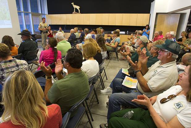People applaud an announcement by Metro Police Captain Patrick Neville during a public meeting at the Red Rock Canyon Visitor Center Sunday, July 14, 2013. Neville announced that Kyle Canyon residents will be allowed to return to their homes on Wednesday.