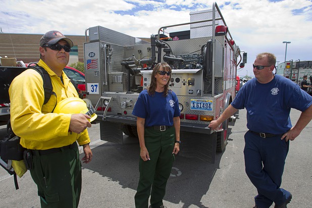 Firefighter/paramedics Charlie Bowman, left, Jennifer Cleppe, and Mark Secrist pose by their brush truck at Centennial High School Sunday, July 14, 2013. The crew headed back to Dayton, Nev. Sunday after assisting on the Mount Charleston wildfire.