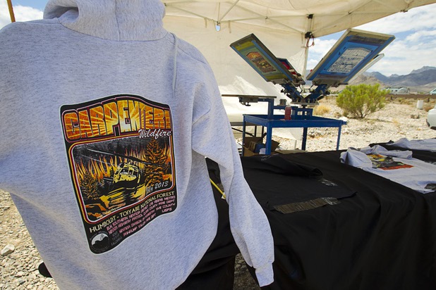A vendor sells commemorative T-shirts and hoodies acoss from Centennial High School Sunday, July 14, 2013.