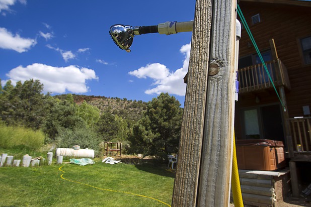 A temporary outdoor shower is shown in Don Kubinski's backyard in Trout Canyon Monday, July 15, 2013. The shower is connected to a small emergency water tank. Residents were allowed to return to their homes Sunday but they have no running water.