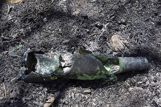A broken bottle is shown in Trout Canyon Monday, July 15, 2013. Residents were allowed to return to their homes Sunday.