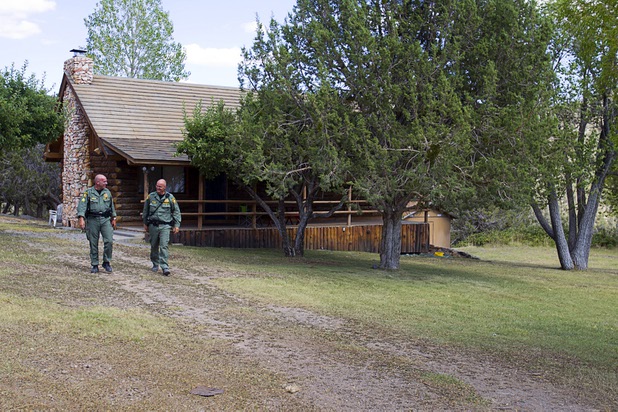 Metro resident officers Sgt. Joe Gibbons, left, and Carl Boehmer walk from a home in Trout Canyon Monday, July 15, 2013. Residents were allowed to return to their homes Sunday.