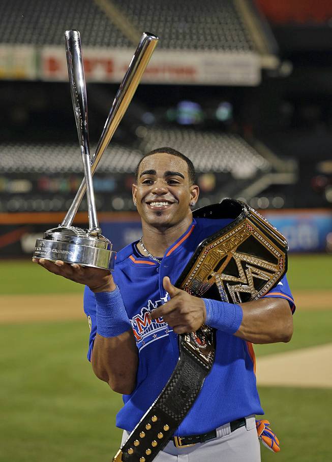 American League's Yoenis Cespedes, of the Oakland Athletics, poses with a trophy and belt after winning the MLB All-Star baseball Home Run Derby, on Monday, July 15, 2013, in New York.