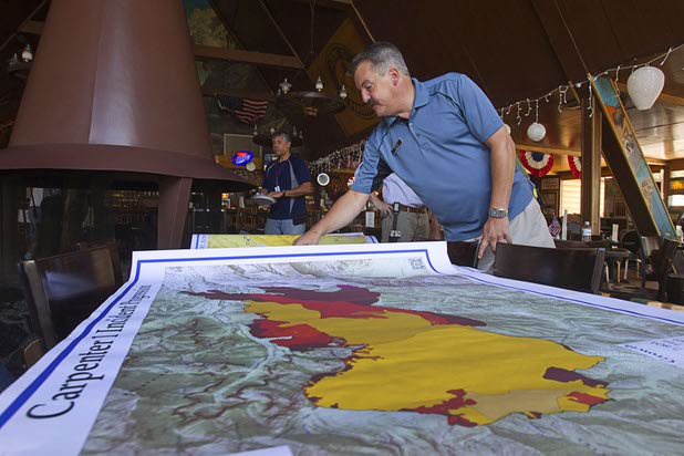 Thomas Schneekloth, manager of the Mount Charleston Lodge, looks over fire maps at the lodge Thursday, July 18, 2013. The mountain is expected to reopen to the public on Friday.