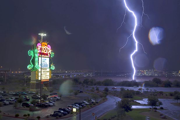 Lightning strikes a fence north of the Fiesta Henderson casino as a storm makes its way across the Las Vegas Valley Friday, July 19, 2013.