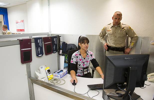 Metro Corrections Captain Rich Suey talks with Katrina Crose, an emergency medical technician, at a pre arrest station in a booking area during a tour of the Clark County Detention Center Tuesday, July 23, 2013.