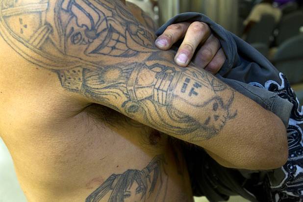 An inmate shows a gang tattoo during a tour of the Clark County Detention Center Tuesday, July 23, 2013.