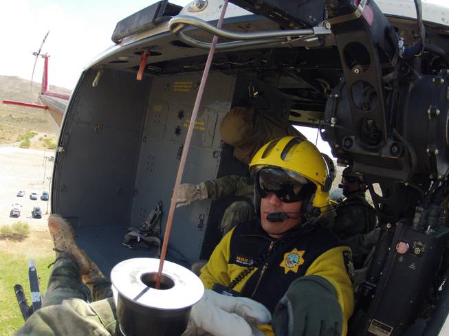 Metro Police Officer David Vanbuskirk, who died Monday while rescuing a stranded hiker, is shown riding in a helicopter near Bonnie Springs in May 2013 while helping train Drug Enforcement Administration agents. 