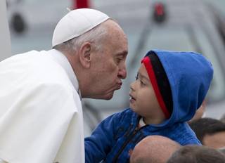 Pope Francis reaches out to kiss a child as he arrives to the Aparecida Basilicia in Aparecida, Brazil, Wednesday, July 24, 2013. 